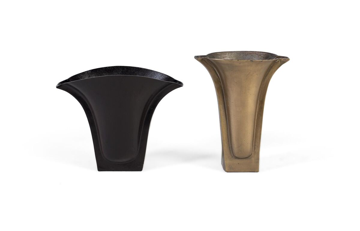 Este set de dos floreros de aluminio destaca por su acabado rugoso en tonos de bronce y latón, que les confiere un carácter artesanal y elegante.